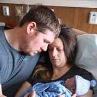 Man and women in hospital bed holding their baby